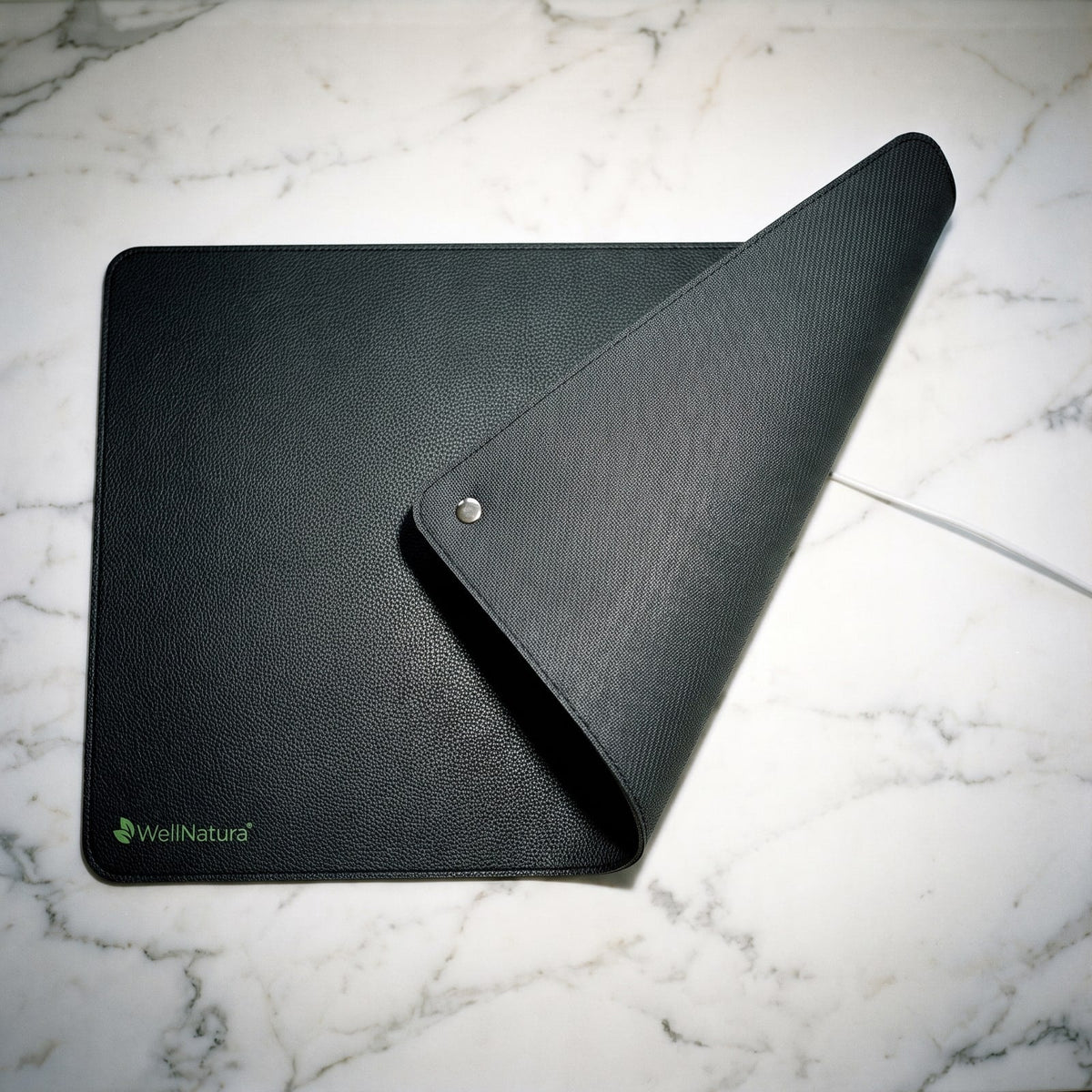 Grounding mat folded to show the vegan leather top and non-slip woven underside