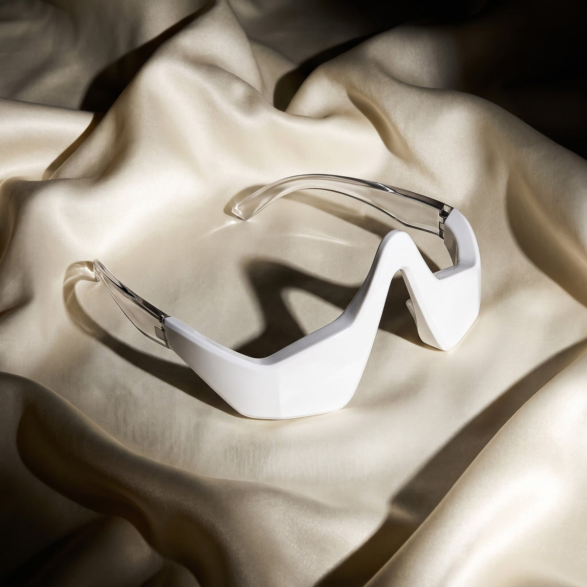Rejuva Eyes device on silk, side view showing the chrome arms
