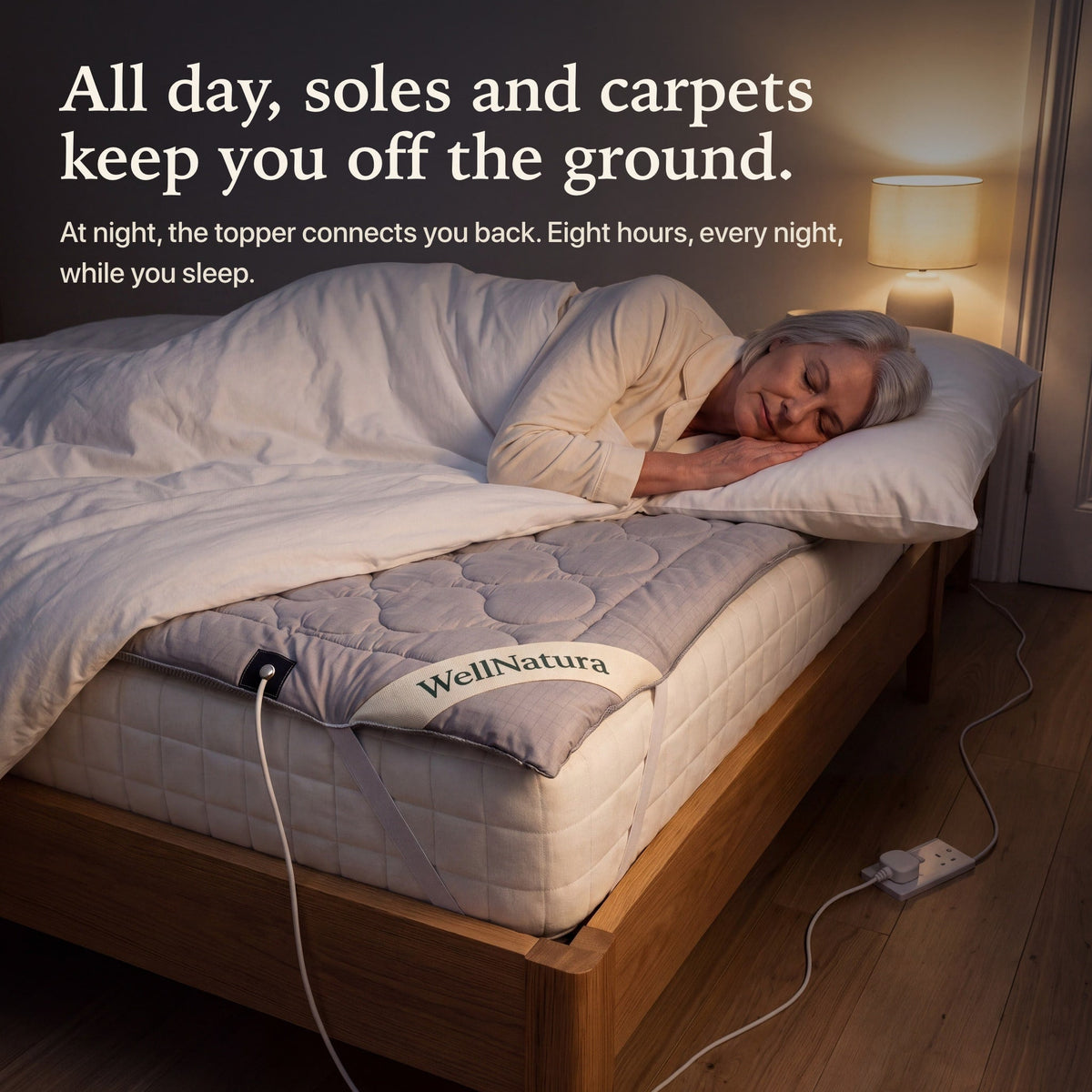 Woman asleep on the grounding topper at night