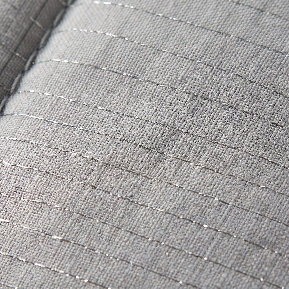 Macro of the silver fibre woven into the cotton top of the grounding topper
