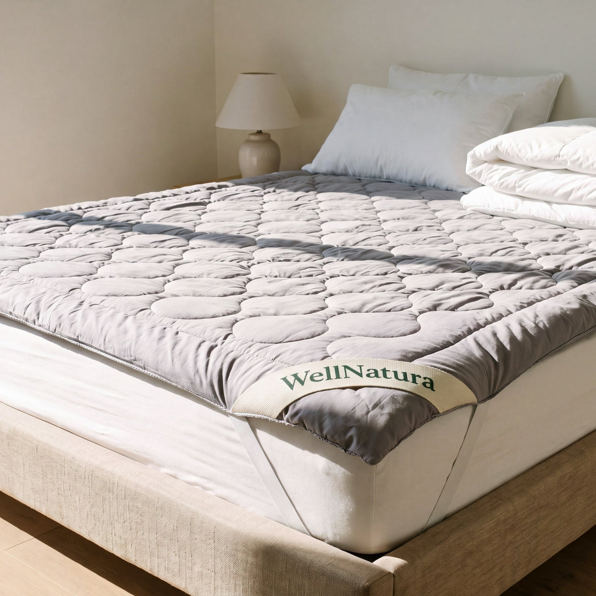 WellNatura grounding topper fitted on a white mattress